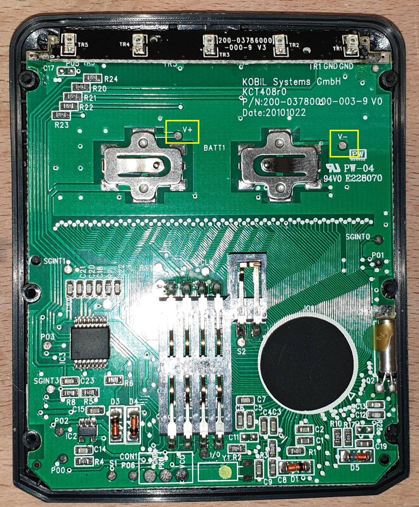 Rückseite der Platine mit gelb markierten Anschlusspunkten V+ und V− neben den Batteriehaltern.